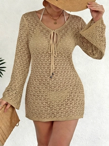 Détail de la robe de plage au crochet avec liens à glands, col en V et manches évasées