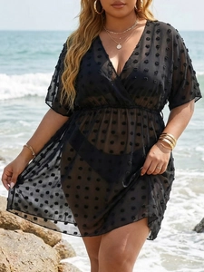 Detail of sheer black Swiss dot beach cover-up with V-neck and elastic waist texture