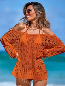Leuchtend orangefarbenes Häkel-Strandkleid mit V-Ausschnitt und langen Ärmeln am Strand