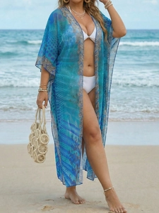 Detail of silver floral embroidery lace on a blue bohemian mesh beach cover-up cardigan