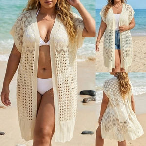 Detail of crochet knit patterns and texture on an off-white oversized beach cover-up
