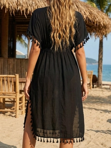 Detail view of black beach cover-up with tassel trim edges and back waist design