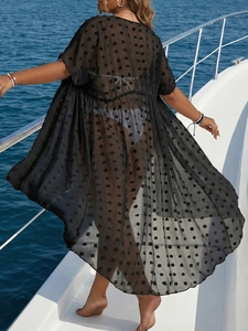 Macro view of black sheer chiffon beach cover-up with textured polka dots on yacht
