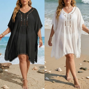 Détail d'une robe de plage avec décolleté en V au crochet et bordures à pompons noirs et blancs