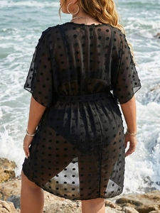 Detail of black Swiss dot mesh beach cover-up with tie waist in a vacation setting