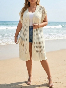 Detail view of cream crochet cover-up with hollow knit patterns and wavy hem edge
