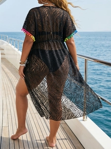 Detail of sheer black cover-up with wavy patterns and colorful pom-pom lace trim