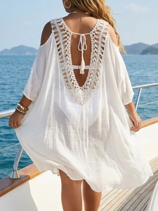 Detail of white crochet beach cover-up with open back and tassel ties on a luxury yacht