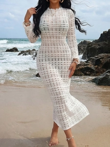 Detail of white crochet knit dress with hollow geometric patterns for beach vacation