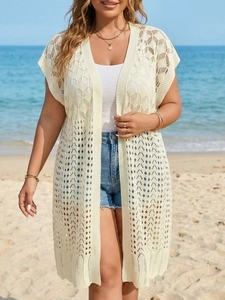 Detailed macro view of the geometric crochet pattern on the beige knit beach cover-up