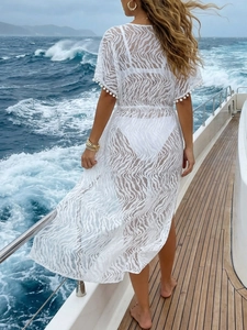 Cache-maillot en dentelle blanche avec manches à pompons et lien à la taille sur yacht