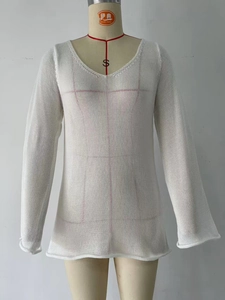 Dettaglio ravvicinato del tessuto in maglia bianca trasparente con scollo a V per copricostume