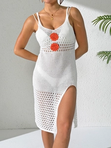 Detail of white crochet beach dress with orange flower applique and knit hollow pattern