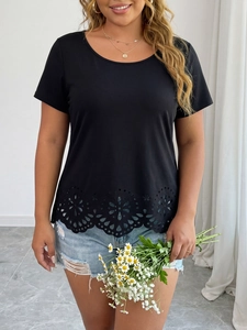 Détail de l'ourlet floral ajouré découpé au laser sur un t-shirt noir à col rond