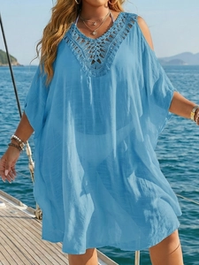 Detail of light blue beach cover-up featuring intricate crochet V-neck and batwing sleeves