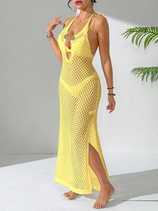 Detail of yellow knit dress featuring a metallic butterfly buckle and halter neckline
