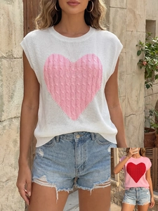 Detail of the oversized cable-knit heart pattern on this sleeveless knit sweater vest