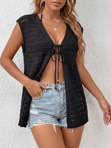 Detail of black crochet knit vest with geometric cutout pattern and front tie lace-up detail