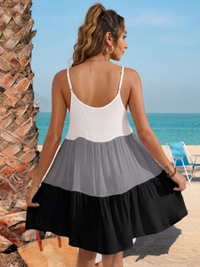 Détail d'une robe longue dos nu avec panneaux de couleurs contrastées sur une plage