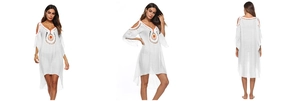 Detail view of white boho beach cover-up with colorful crochet embroidery and lace patterns