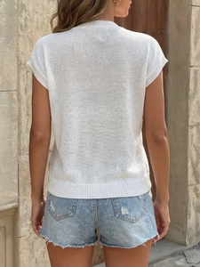 Back view of a casual white heart knit top paired with distressed denim shorts