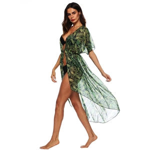 Detail of translucent green tropical leaf print beach cover-up with side slit