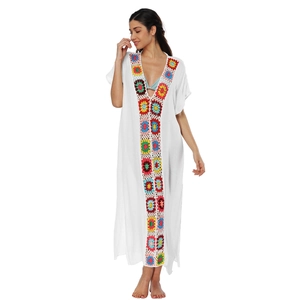 Dettaglio di fiori all'uncinetto fatti a mano su un copricostume bianco con scollo a V