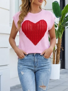 Close-up of pink knit top featuring a large red heart intaglio and ribbed round neck