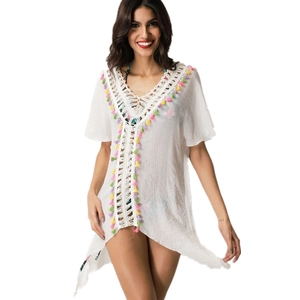 Detail of white boho beach cover-up with crochet deep V-neck and colorful fringe accents