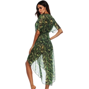 Detail of tropical leaf print and sheer fabric on woman's asymmetrical beach cover-up