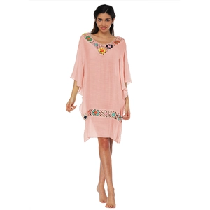 Détail de la broderie florale au crochet colorée sur une robe de plage rose bohème