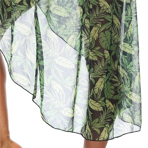 Detail of green tropical leaf print on lightweight sheer chiffon fabric with irregular hem
