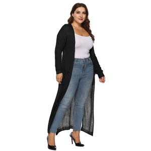 Dettaglio della trama a maglia fine di un cardigan lungo nero aperto da donna elegante