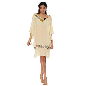 Détail de motifs floraux en crochet faits main sur une robe de plage bohème aux couleurs vives