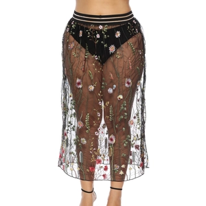 Détail de broderie florale sur jupe en tulle noir avec taille élastique rayée