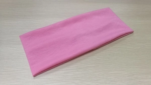 Detailed view of pink elastic yoga headband showing breathable knitted fabric texture