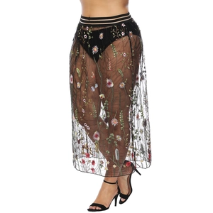 Détail de la broderie florale colorée sur jupe longue en tulle noir semi-transparente