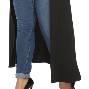 Detail of dark blue skinny jeans with cuffed hems and black patent leather stiletto heels