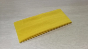 Close-up of bright yellow elastic yoga headband with soft cotton fabric texture