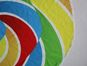 Detail of colorful geometric print beach towel featuring fine white lockrand stitching