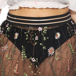 Détail de broderie florale sur jupe en tulle noir avec taille élastique rayée