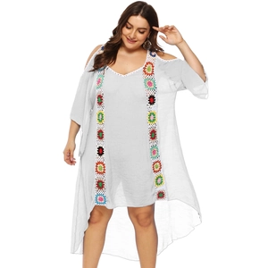 Detalle de bordado de flores a ganchillo en vestido playero boho gris con cuello en v