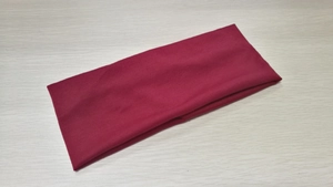 Detail of the soft knit fabric and elastic texture of the dark red wide sports headband