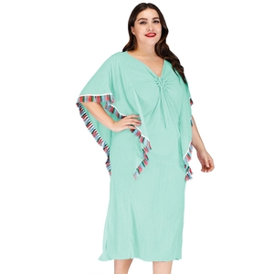 Détail de la robe kaftan bohème vert menthe avec glands colorés et décolleté en V plissé