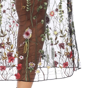 Détail de broderie florale colorée sur tulle noir de la jupe trapèze d'été chic
