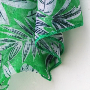 Close-up of the fine edge stitching and green tropical leaf print on lightweight fabric