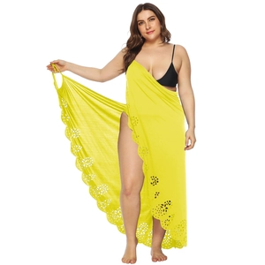 Detail of bright yellow beach sarong with laser-cut floral patterns and sheer fabric