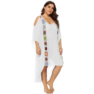 Detalle de vestido playero blanco de talla grande con bordados florales de ganchillo