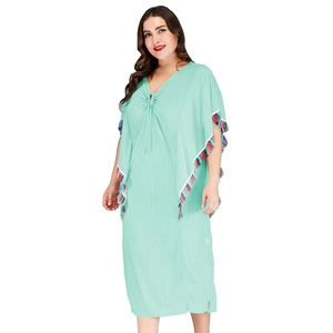 Détail de robe de plage vert menthe avec col en V, pompons colorés et cordon bohème