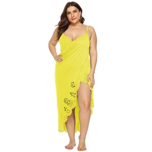 Detail of laser-cut floral patterns on the hem of a bright yellow summer beach dress